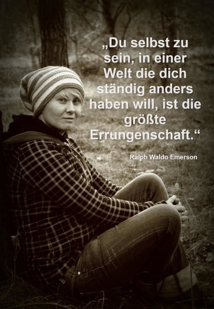 Frau mit Mütze, die im Wald an einem Baum gelehnt sitzt.
