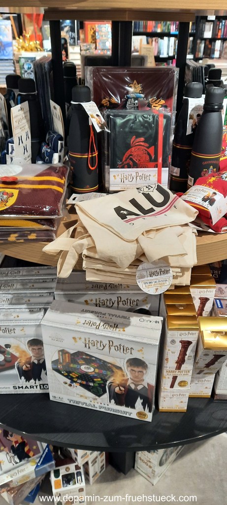 Ein Tisch voll mit Harry Potter Merchandise- Trinkflaschen, Einkaufstaschen, Spiele