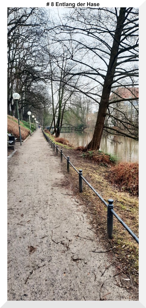 Ein Weg aus Sand neben einem Fluss andessen Ufer Bäume stehen