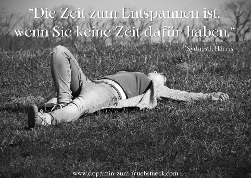 Schwarz weiß Foto einer Frau, die mit ausgestreckten Armen auf dem Rücken auf einer Wiese liegt