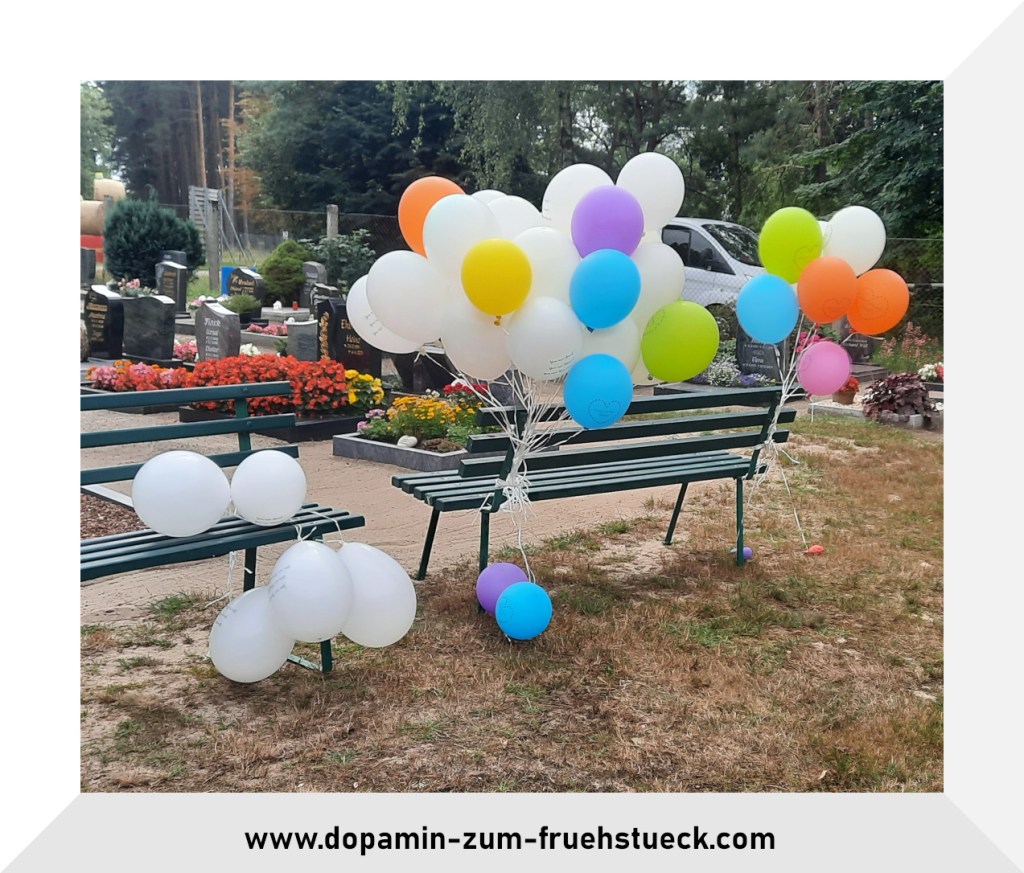 bunte Luftballons befestigt an einer Bank