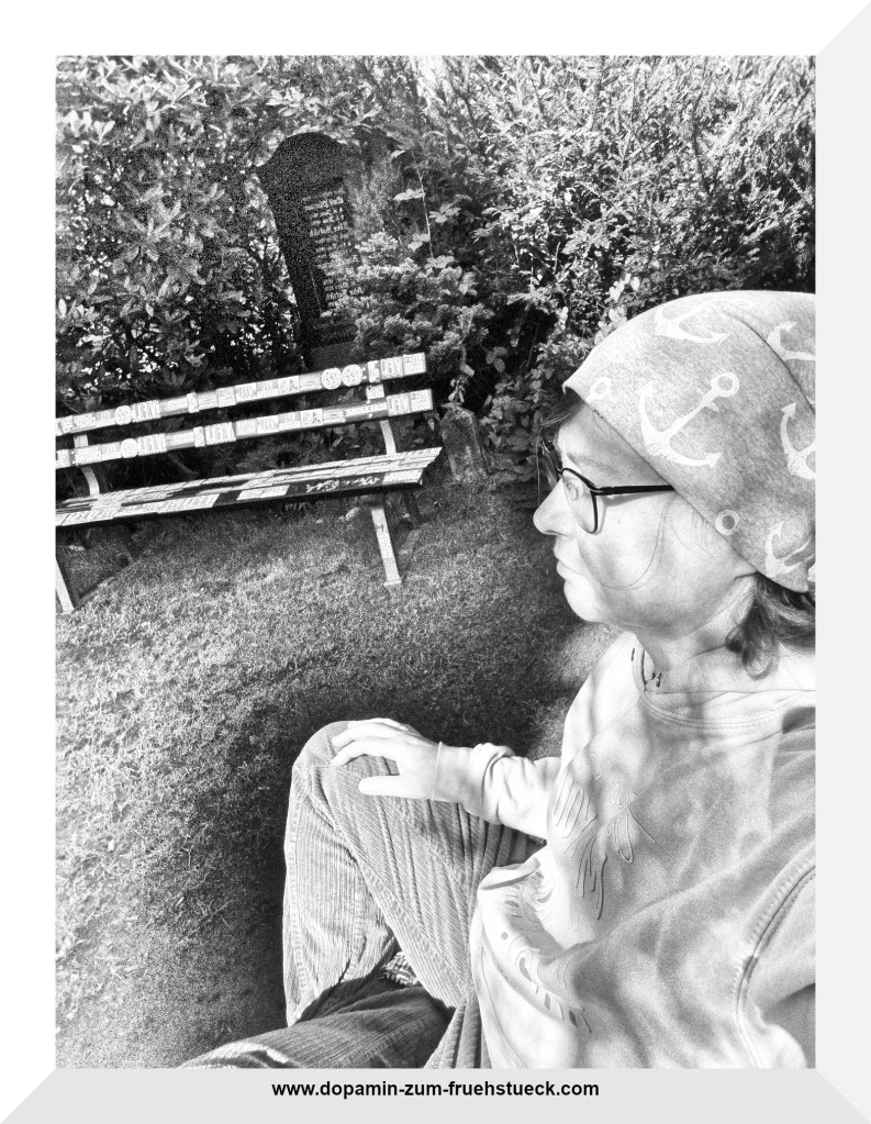 Schwarz- weiß Foto einer Frau mit Mütze und Brille, die in der Natur meditiert