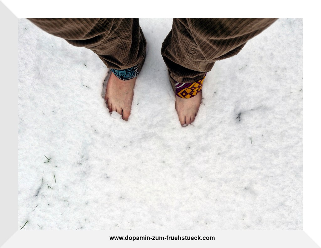 Nackte Füße, die im Schnee stehen