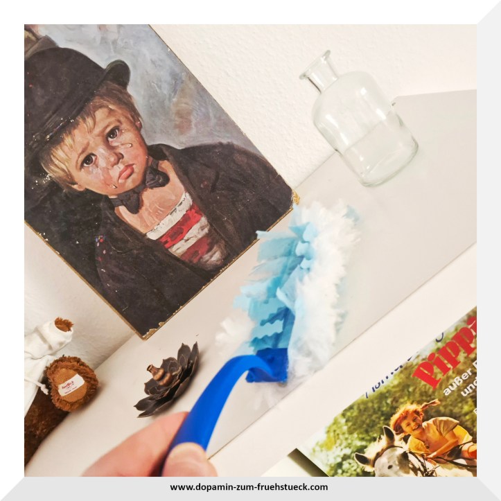 Ein Staubwedel auf einem Regal