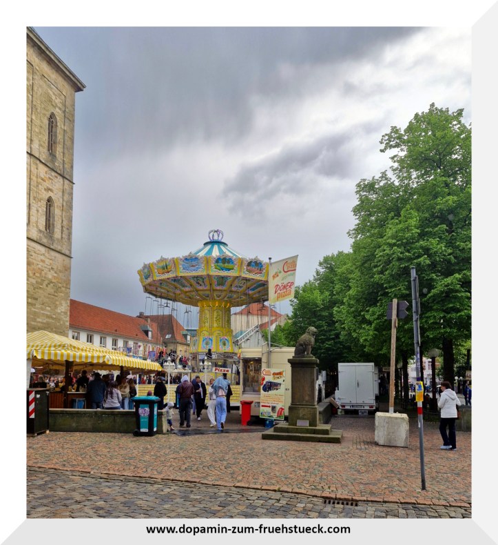 Ein Kettenkarussell bei grauem Himmel auf einem Marktplatz
