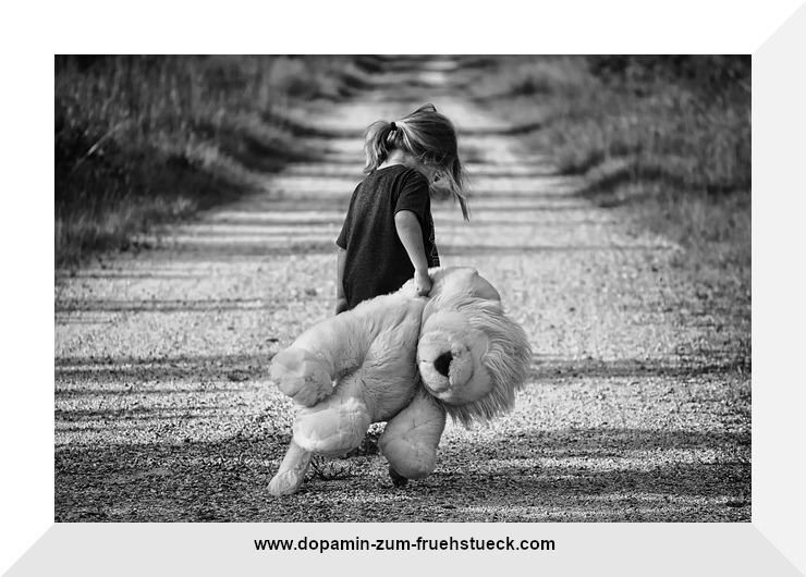 Schwarz- weiß Foto. Ein Mädchen ( ungefähr 4- 5 Jahre alt) steht allein mit einem Teddy im Arm auf einem Weg. Der Kopf des Mädchens ist gesenkt