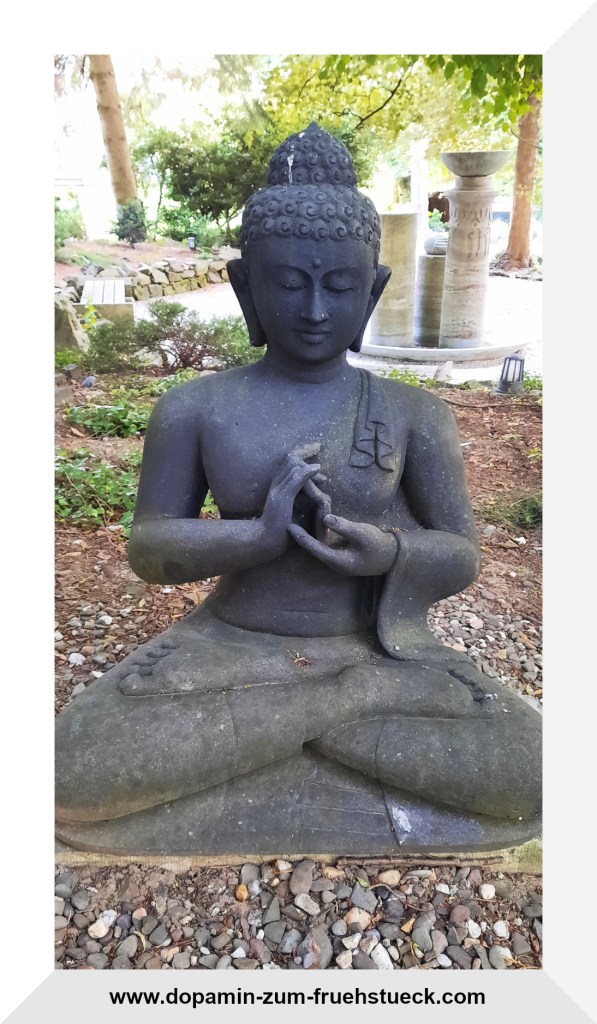 Eine sitzende Buddha- Statue, die auf dem Gelände eines Klosters steht